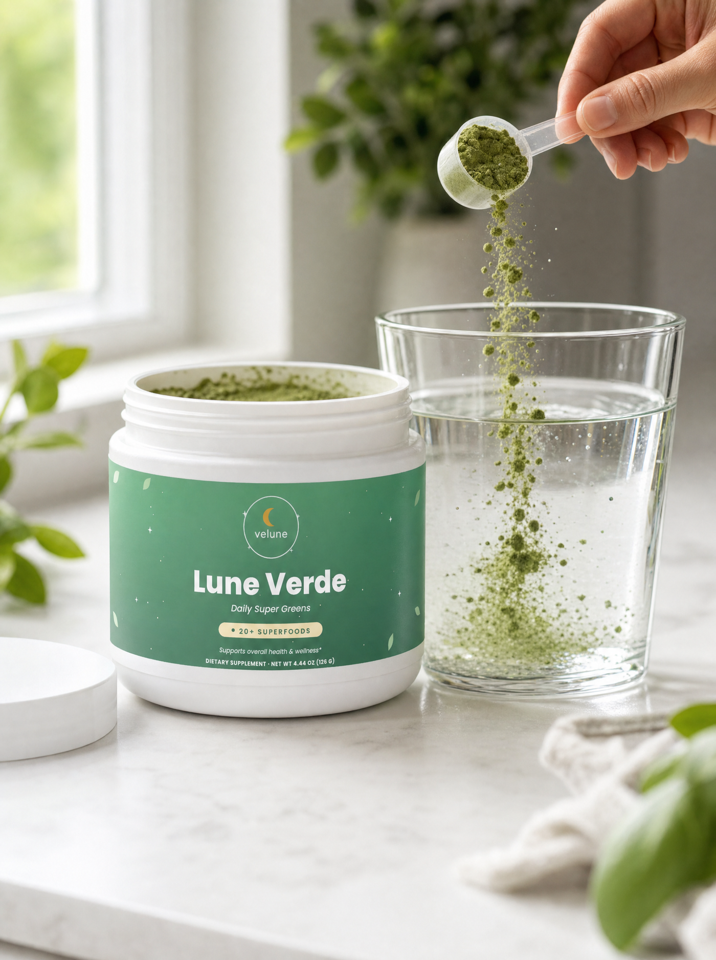Scooping Lune Verde greens powder into a glass